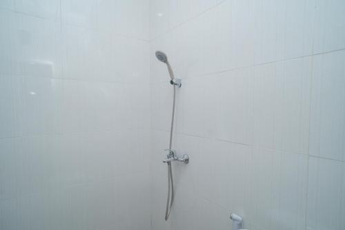 a shower with a shower head in a bathroom at RedDoorz @ Jalan Gunung Talang Mahendradatta in Kerobokan