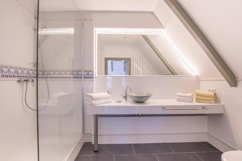W łazience znajduje się prysznic, umywalka i lustro. w obiekcie Friesenhaus Sara S2 w mieście Wenningstedt