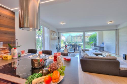 una cocina y una sala de estar con una mesa con verduras. en Rebecca Garden - Happy Rentals en Lugano