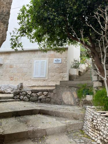 a building with stairs and a window and a tree at Apartmani Rustica in Drasnice