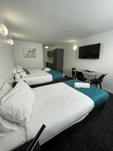 a hotel room with two beds and a table at Barham Bridge Motor Inn in Barham
