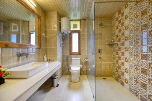 a bathroom with a sink and a toilet at Clarks Inn Suites, Manali in Manāli