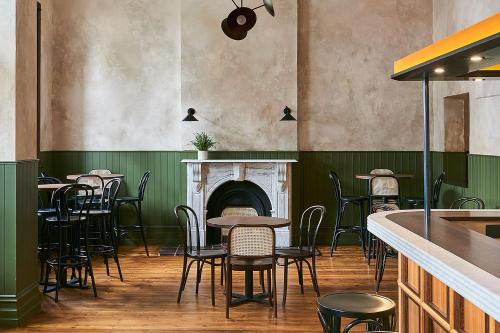 a restaurant with tables and chairs and a fireplace at Portarlington Grand Hotel in Portarlington
