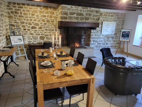 une salle à manger avec une table et une cheminée dans l'établissement La Fée des Greves, à Roz-sur-Couesnon
