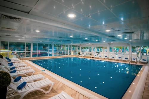a large swimming pool on a cruise ship with lounge chairs at Prestige Deluxe Hotel Aquapark Club - All inclusive in Golden Sands