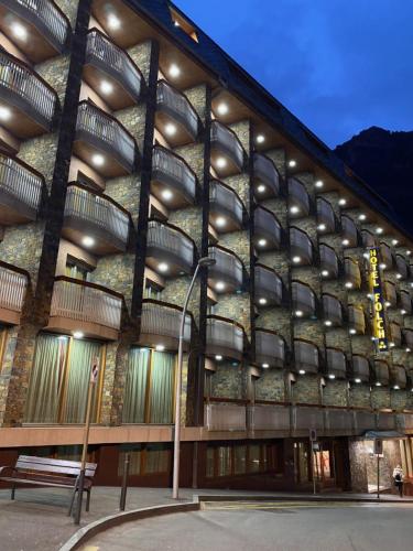 um edifício com um banco à frente em Hotel Folch em Sant Julià de Lòria