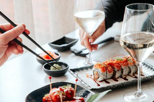 a table with plates of food and glasses of wine at Van der Valk Hotel Beveren in Beveren
