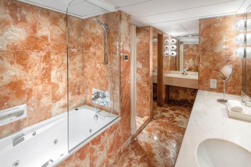 a bathroom with a shower and a sink at Regal Riverside Hotel in Hong Kong