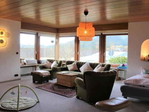 sala de estar con sofá, sillas y ventanas en Große Wohnung mit Balkon Sulzbergblick in Alpirsbach, en Alpirsbach