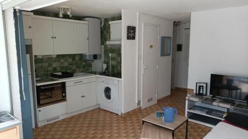 a kitchen with white cabinets and a washing machine at Lara 6 - Grand T2 Terrasse Loggia - WC indép - Parking - Quartier calme entre centre-port et île des Loisirs plage Richelieu in Cap d'Agde