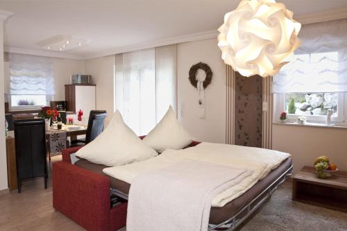 1 dormitorio con cama y lámpara de araña en Kleines Glück in Willingen &MeineCardPlus, en Willingen