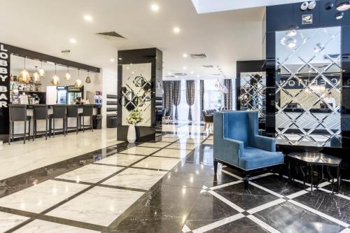 a lobby with a blue chair in a store at Prestige Deluxe Hotel Aquapark Club - All inclusive in Golden Sands