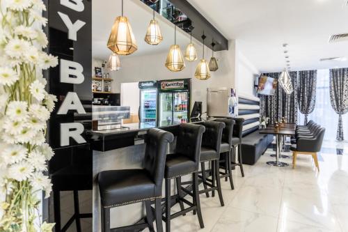 a bar with black leather bar stools at Prestige Deluxe Hotel Aquapark Club - All inclusive in Golden Sands
