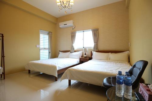 a bedroom with two beds and two bottles of water at Taitung Nine Three B&B in Taitung City