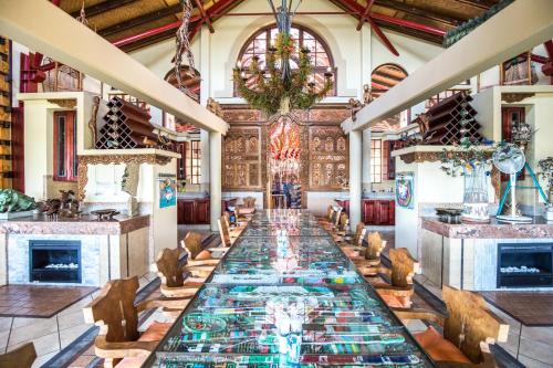 a long table in the middle of a room with fireplace at AmmaZulu African Palace in Kloof