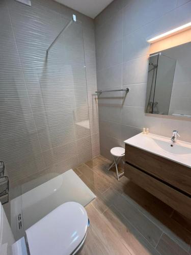 a bathroom with a toilet and a sink and a shower at Apartamento Solaris T1 - Férias Albufeira in Albufeira
