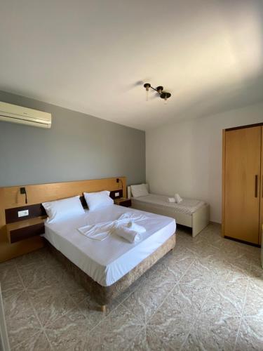 1 dormitorio con 1 cama blanca grande y armario en EDGEWATER apartments, en Sarandë