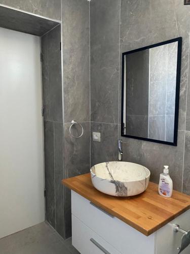 uma casa de banho com um lavatório e um espelho em EDGEWATER apartments em Saranda