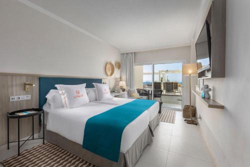 a bedroom with a large bed with a view of the ocean at Corallium Dunamar by Lopesan Hotels - Adults Only in Playa del Ingles