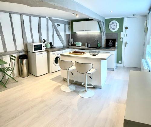 - une cuisine avec un comptoir et deux tabourets dans l'établissement La Porte Cauchoise - Hypercentre coquet branché, à Rouen