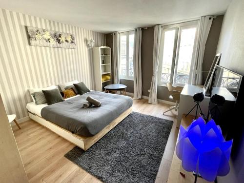 une chambre avec un lit et une grande fenêtre dans l'établissement La Porte Cauchoise - Hypercentre coquet branché, à Rouen