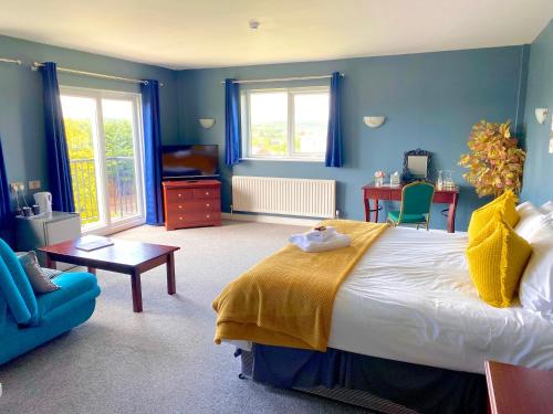 a bedroom with a large bed and a blue wall at Bells Hotel in Coleford
