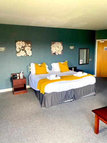 a bedroom with a large bed with yellow pillows at Bells Hotel in Coleford