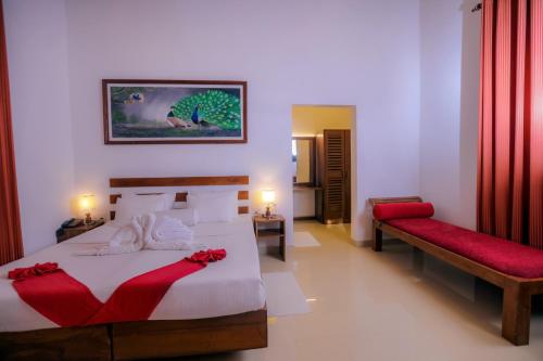 a bedroom with a large bed with red accents at Sigiri Asna Nature Resort in Sigiriya