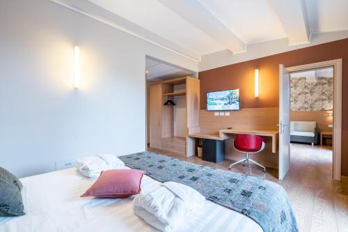 a bedroom with a bed and a desk with a red chair at Relais Bellaria Hotel & Congressi in Bologna