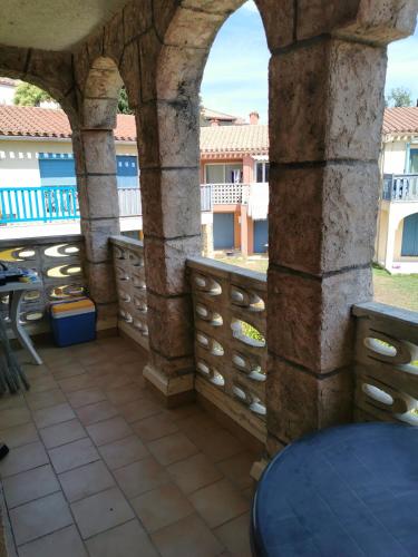 - une terrasse avec une bande de tiroirs et une arche dans l'établissement Charmant appartement avec piscine dans un village vacance, à Canet