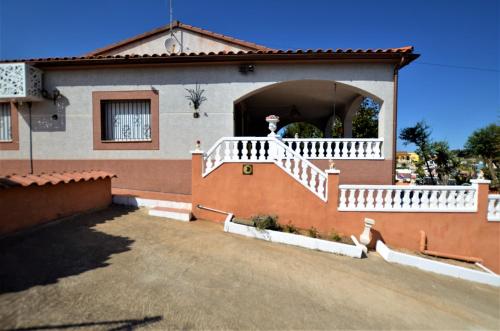 a house with a white railing and a porch at Villa Olombel in Maçanet de la Selva