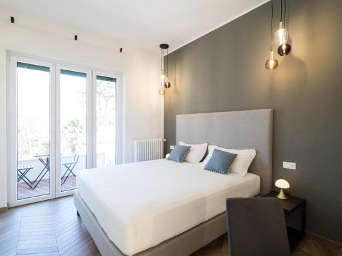 a bedroom with a large white bed and a balcony at Savoia Rooms Roma in Rome