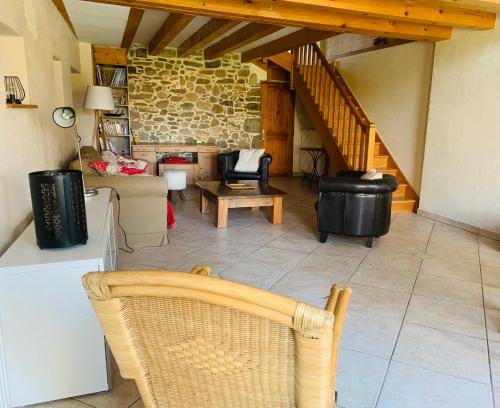 un salon avec un canapé et un escalier dans l'établissement Maison de village entre lac et montagnes, à Loisin