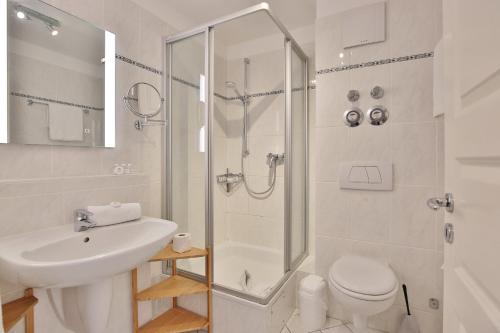 La salle de bains est pourvue d'une douche, de toilettes et d'un lavabo. dans l'établissement Hansa-Residenz I Hansa-Residenz I Appartement 1, à Scharbeutz