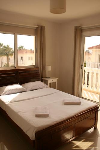 a bedroom with a large bed with two towels on it at Nissi Villa in Ayia Napa