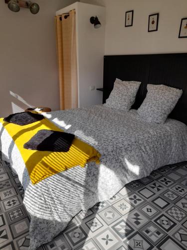 um quarto com uma cama com um edredão amarelo e preto em L'Inattendu em Saint-Sébastien-sur-Loire