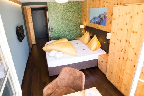 a small room with a bed and a chair at Wohlfühlhotel Hubertushof in Stuben am Arlberg
