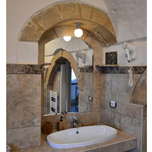 a bath tub in a bathroom with a large mirror at Gradelle Pennino in Matera