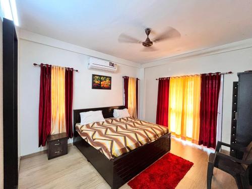 a bedroom with a bed and red curtains at Pushpam Sanskruti Resort Karjat- Pure Veg in Karjat