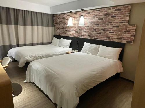 a hotel room with two beds and a brick wall at 苓旅中山館-Lininn ZhongShan in Taipei