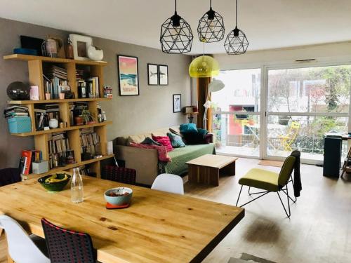 un salon avec une table et un canapé dans l'établissement Maison de ville entre Darwin et Jardin botanique, à Bordeaux
