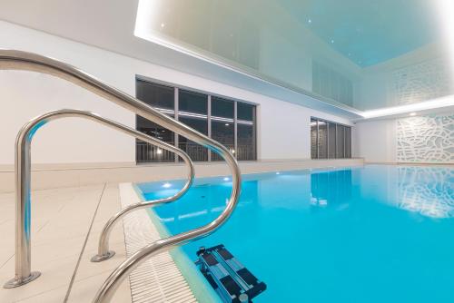 a large swimming pool with a glass walled at Waterlane Apartment SPA&Wellness, Pool by Renters in Gdańsk