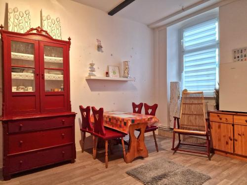 uma sala de jantar com um armário vermelho e uma mesa em Gästequartier mittendrin in Coswig Anhalt em Coswig