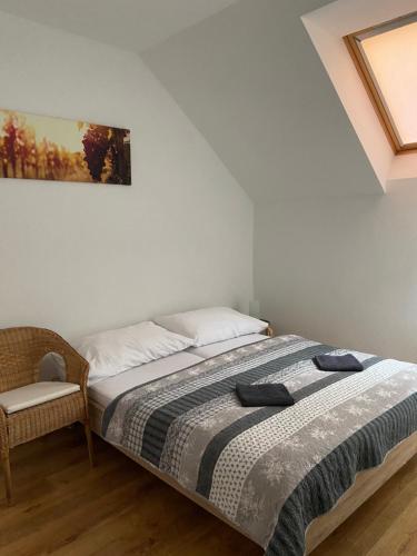 a bedroom with a bed and a chair at Vinařský apartmán Simenon in Chvalovice