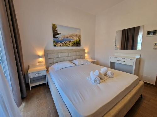 a bedroom with a bed with towels on it at Hotel Queen Margaret Seaside in Ksamil