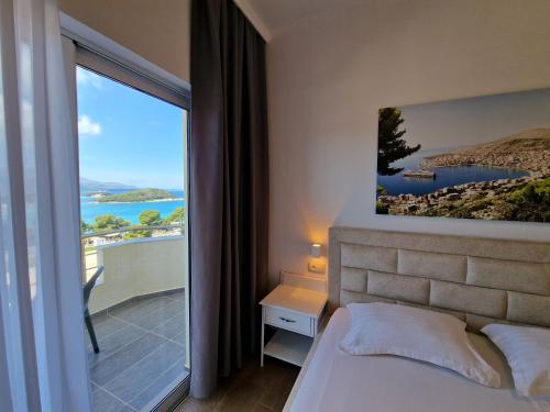 a bedroom with a bed and a window with a view at Hotel Queen Margaret Seaside in Ksamil
