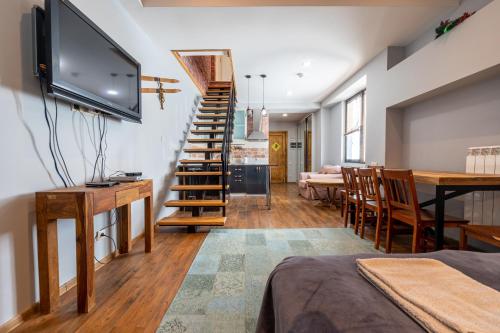 a living room with a staircase and a dining room at New Gudauri Suites in Gudauri