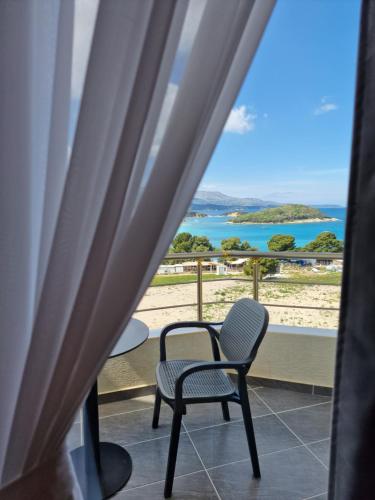 a room with a chair and a view of the ocean at Hotel Queen Margaret Seaside in Ksamil
