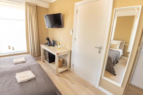 een kleine kamer met een bed en een spiegel bij Hotel Restaurant Toxopeus in Anjum