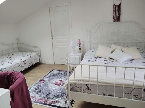 - une chambre blanche avec 2 lits et un tapis dans l'établissement Villa Ker Sanmamaleo près de la plage - 4 chambres, 3 salles de bain, Wifi, animaux acceptés - FR-1-542-29, à Pleumeur-Bodou